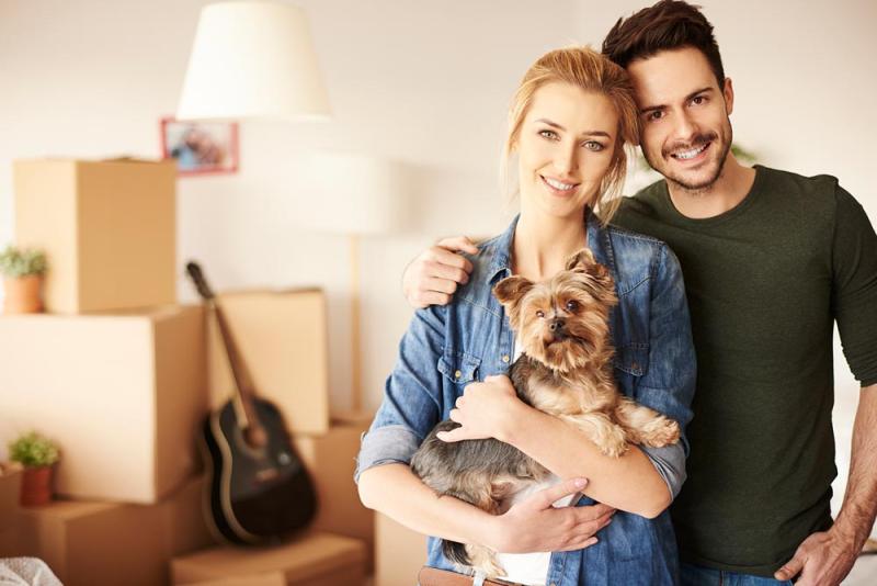 Happy couple moving with a pet.